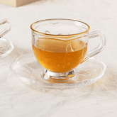 xicara de chá com borboleta de vidro e cristal com pires na mesa de café da amanhã